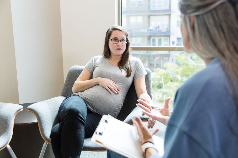 Pregnant person talking to midwife