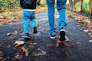 Children walking down a path covered in leaves