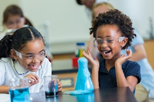 Two children laughing wearing eye protectors