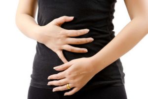 Woman clutching both hands over stomach