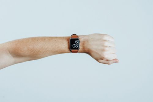 Arm showing wrist watch with a light brown strap