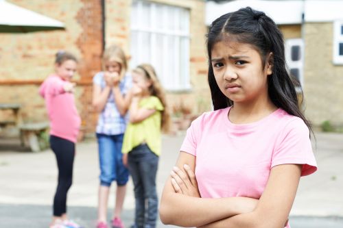 Sad child in pink t-shirt with arms crossed