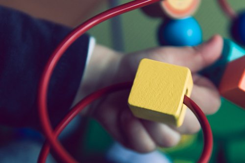 Hand playing with yellow wood block
