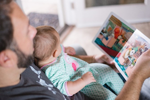 Man reading book with baby on lap Man reading book with baby on lap