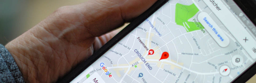 Person holding phone with Google Maps open Person holding phone with Google Maps open