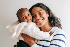 Smiling mother with baby in white dressing gown