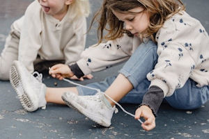 Young girl tying shoelace on plimsoll Young girl tying shoelace on plimsoll