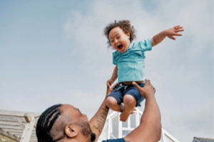 Man holding young child in the air