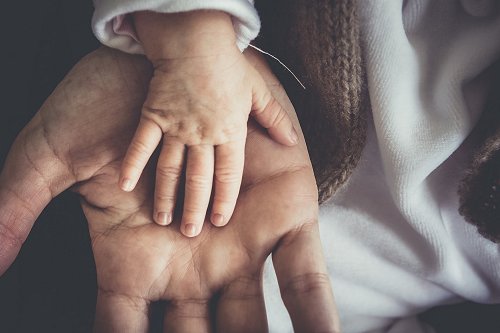 Young child hand in adult hand