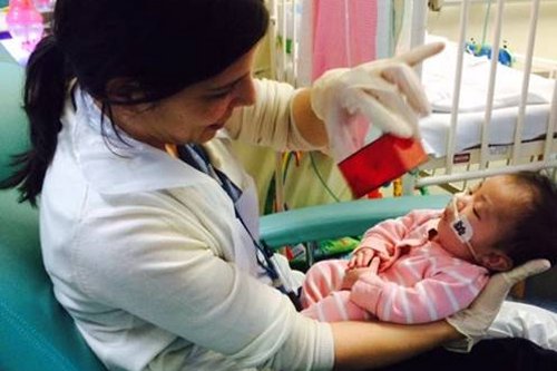 Female occupational therapist holding newborn baby