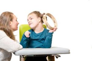 Girl with disability in chair with tambourine Girl with disability in chair with tambourine