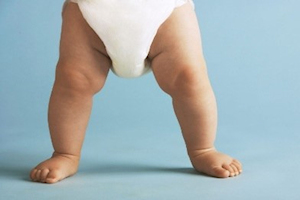 Legs of baby standing in nappy