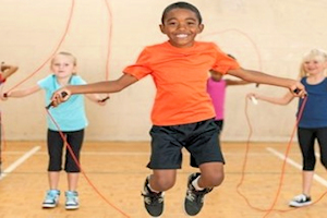 Young boy in orange t shirt skipping