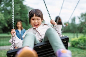 Laughing child on a swing