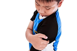Boy holding upper left arm