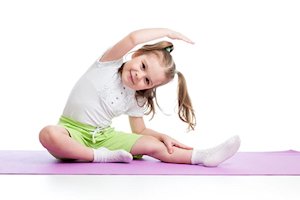 Young girl on exercise mat with right arm stretched over head
