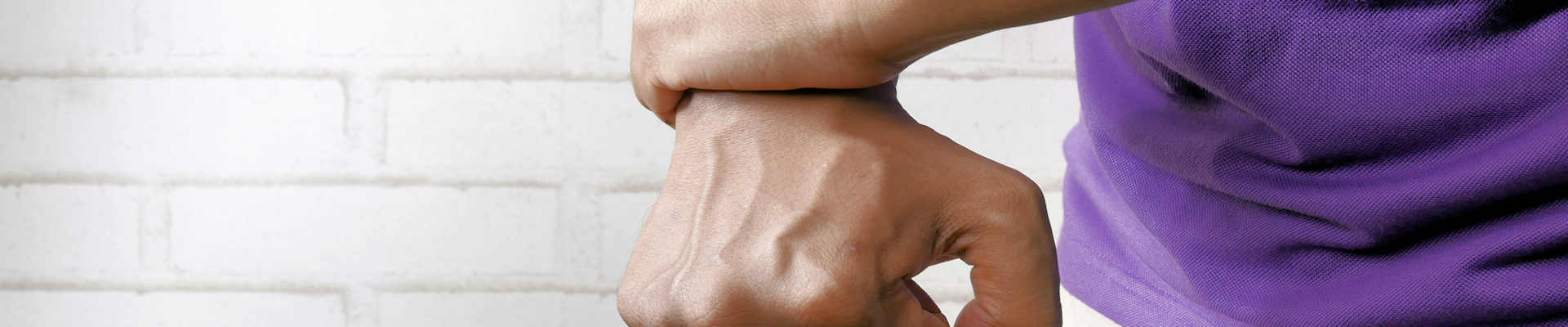Person holding wrist with other hand