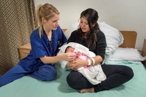 Midwife with mother and baby