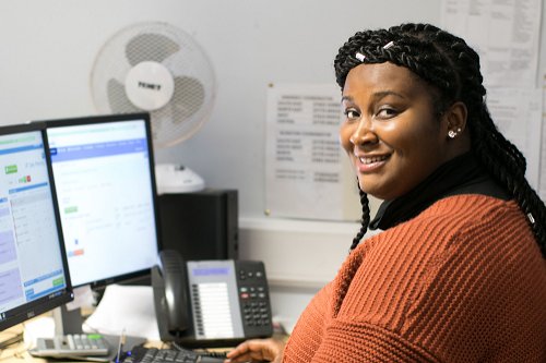 Smiling administrator sitting in front of a computer