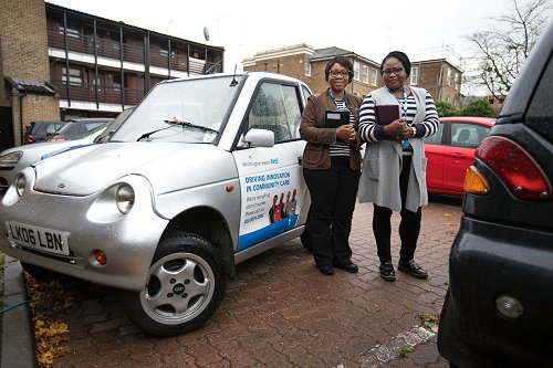 2 nurses standing by a silver car