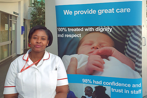 Nurse about to qualify standing in front of We Provide Great Care sign