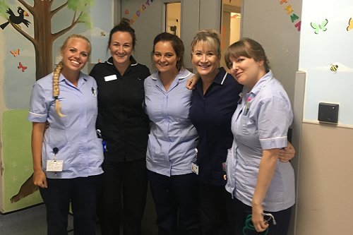 5 nurses standing side by side