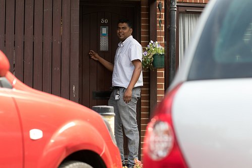 District nurse standing outside door of house