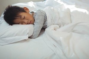 Young boy asleep in bed