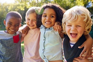 Four children smiling in a row