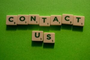 Contact Us spelt using Scrabble tiles