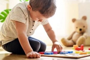 Young boy playing with wooden jigsaw