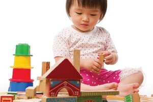 Young girl playing with wooden block toys