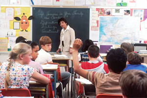 Boy with raised arm in a classroom Boy with raised arm in a classroom