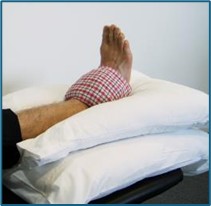 Image of foot raised on pillows