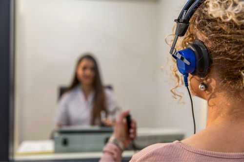 Patient wearing headphones holding a clicker Patient wearing headphones holding a clicker